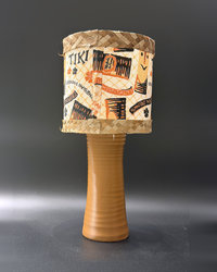 Tiki Bob tiki table lamp, lit, with vintage-inspired print shade