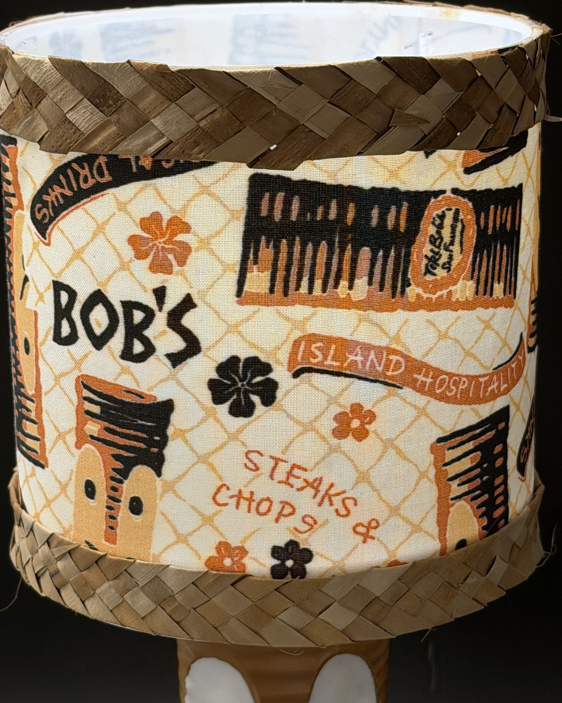 Tiki Bob tiki table lamp, lit, with vintage-inspired print shade